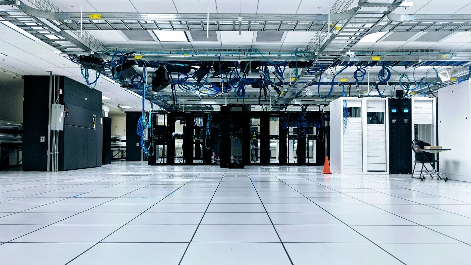 Server cabinets beneath overhead blue network cables